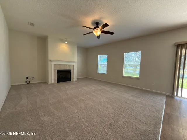 an empty room with a window and a ceiling fan