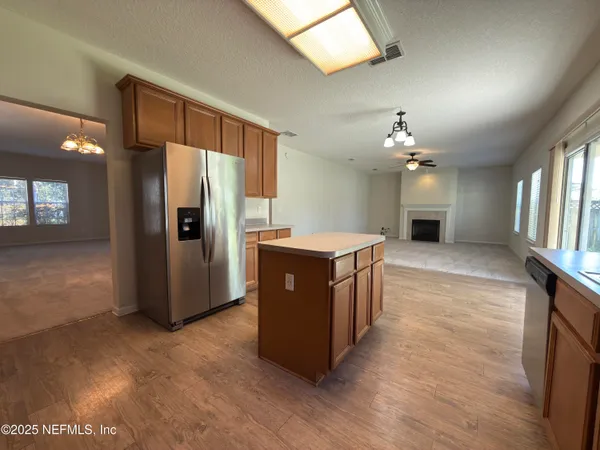 a large kitchen with stainless steel appliances granite countertop a refrigerator a sink and a dishwasher