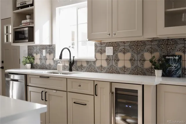 a kitchen with sink a microwave and cabinets