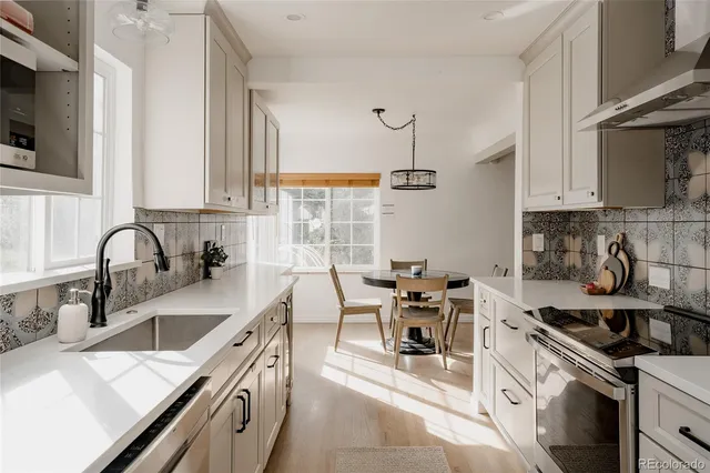 a kitchen with stainless steel appliances a sink a stove and cabinets