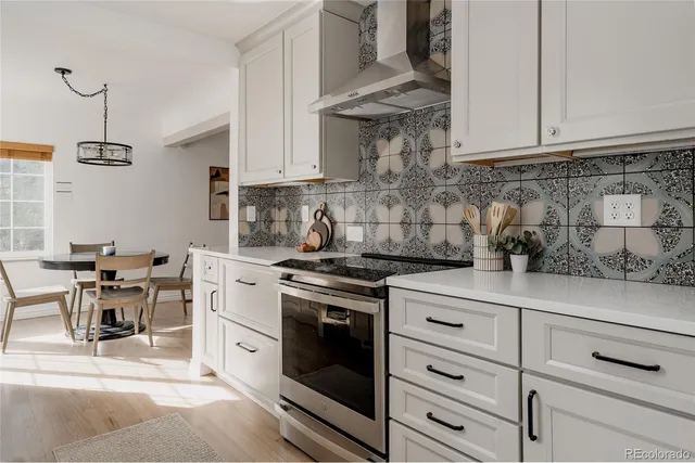 a kitchen with stainless steel appliances granite countertop a stove a white cabinets and a granite counter tops