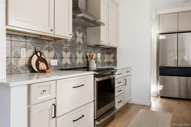 a kitchen with white cabinets and a stove