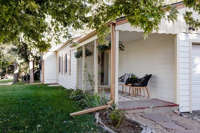 a patio with table and chairs and potted plants