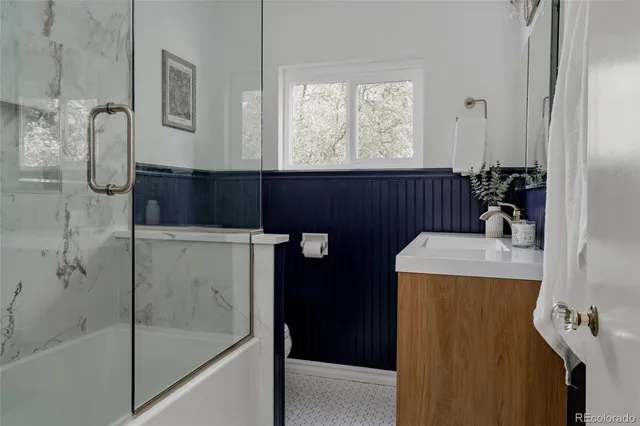a bathroom with a sink a toilet and shower
