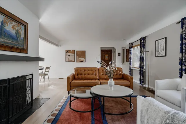 a living room with furniture a fireplace and kitchen view