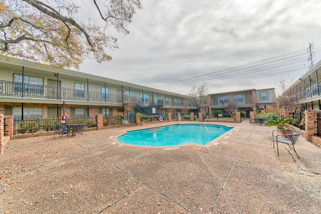 a view of a swimming pool with a patio and a yard