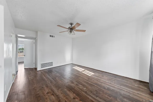 a view of a room with wooden floor and a ceiling fan