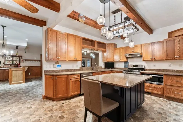 a kitchen with stainless steel appliances granite countertop a sink a stove and a refrigerator