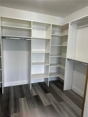 a view of walk in closet with empty racks