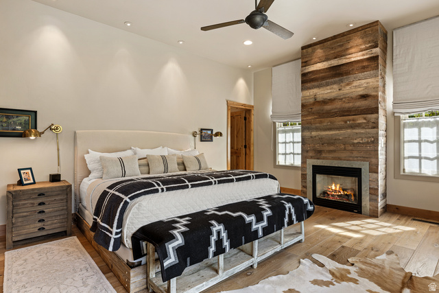 105 River Bend Circle, Unit 105 Springdale, UT 84767 - Photo 10 of 56 Bedroom featuring a floor-to-ceiling wood-paneled fireplace with a stone surround, light wood-finish flooring, and recessed ceiling lights