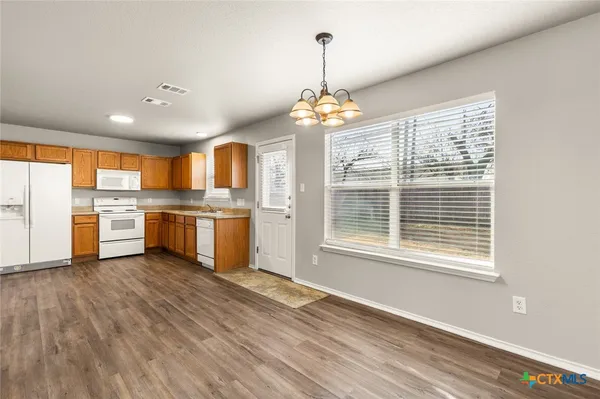 a view of kitchen with granite countertop cabinets and refrigerator