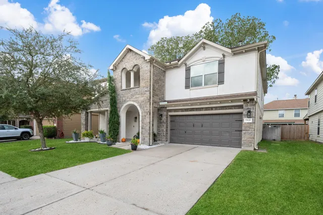 a front view of a house with a yard and garage