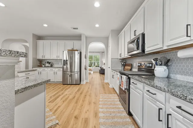 a kitchen with stainless steel appliances granite countertop a stove a sink and a refrigerator