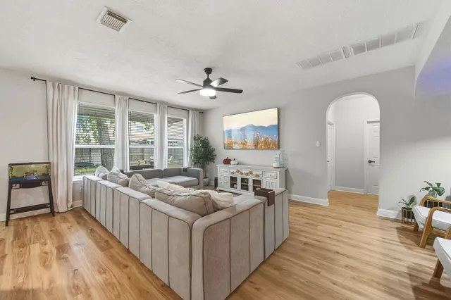 a living room with stainless steel appliances kitchen island furniture and a large window