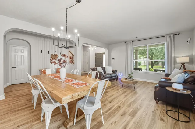 a view of a dining room with furniture a chandelier and wooden floor