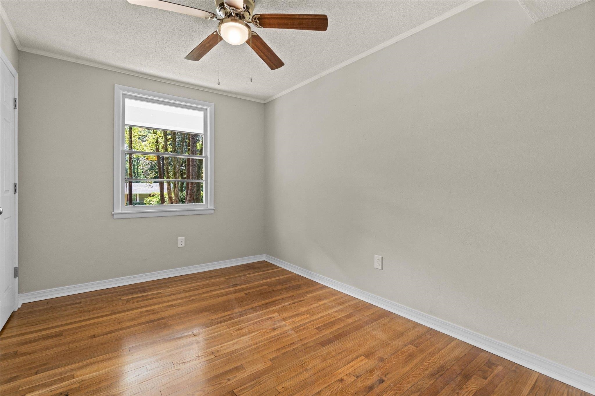 4700 Bit And Spur Road Mobile, AL 36608 - Photo 16 of 21 Empty room with baseboards, a textured ceiling, hardwood / wood-style flooring, and ceiling fan