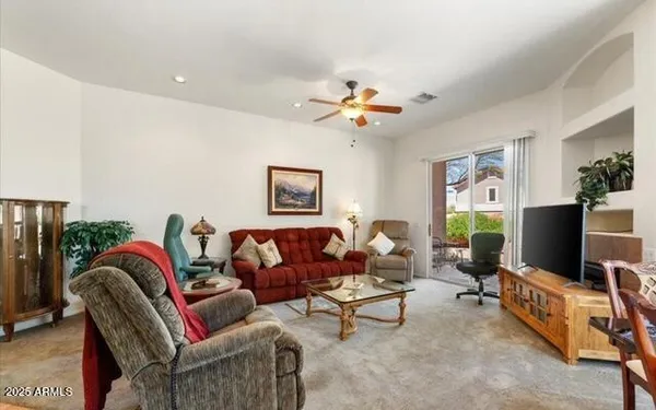 a living room with furniture a flat screen tv and a window