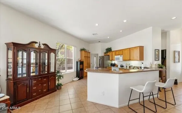 a kitchen with stainless steel appliances kitchen island granite countertop a refrigerator and a stove top oven