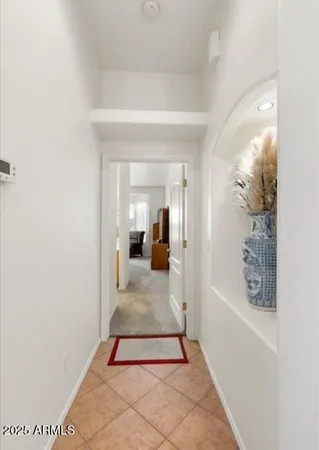 a hallway with a white cabinet and a mirror