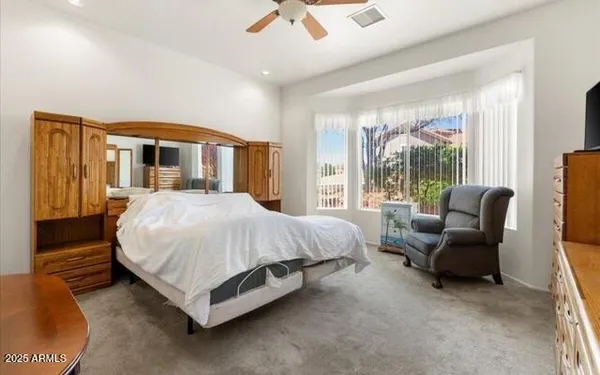 a spacious bedroom with a bed and glass windows