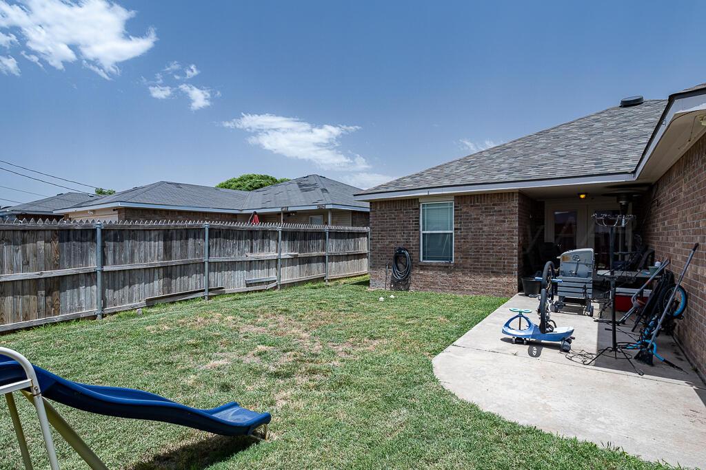 4808 Mammoth Lane Amarillo, TX 79110 - Photo 13 of 15 a view of a backyard with table and chairs a barbeque and wooden fence