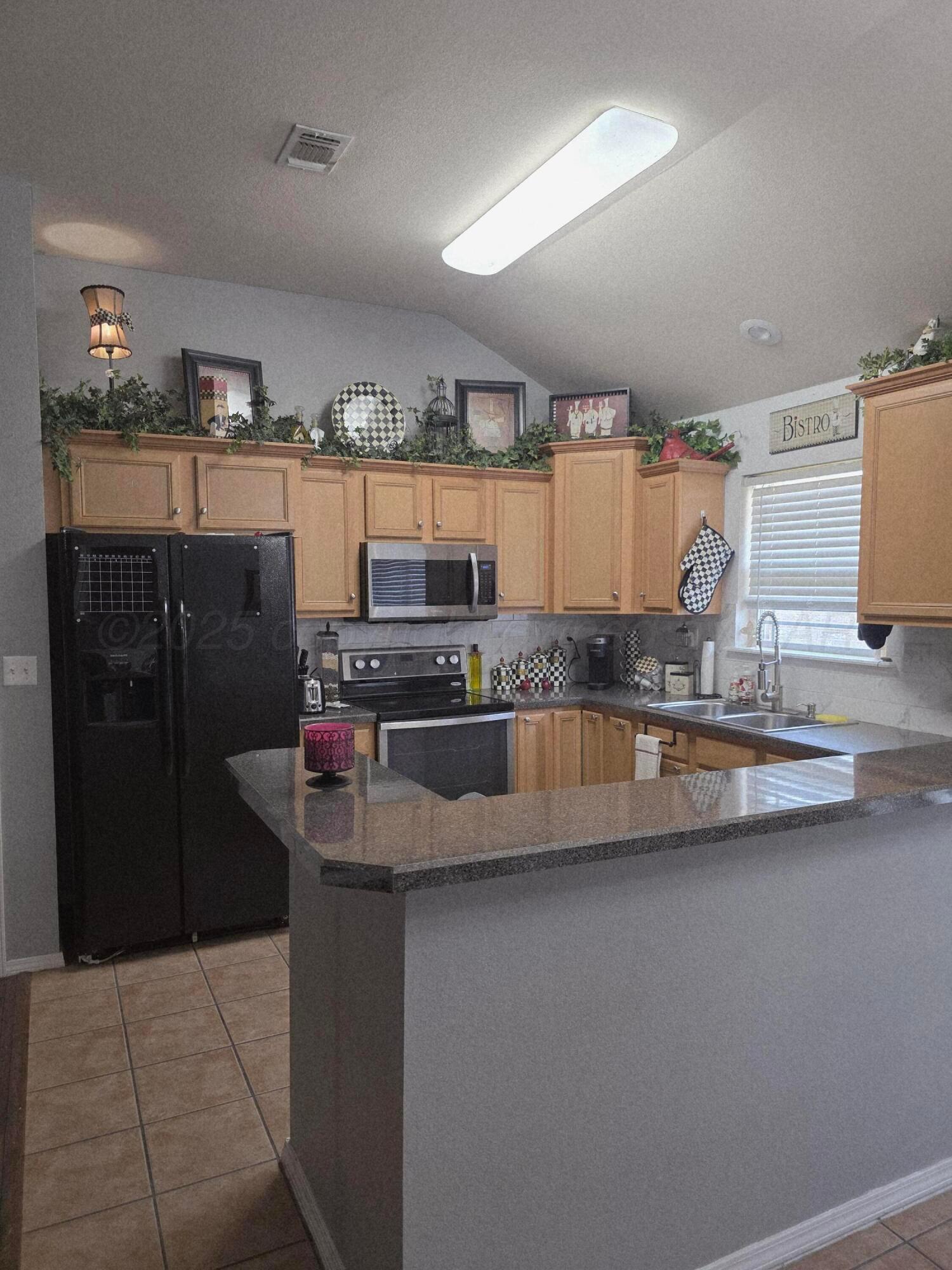 4808 Mammoth Lane Amarillo, TX 79110 - Photo 3 of 15 a kitchen with stainless steel appliances granite countertop a refrigerator and a stove