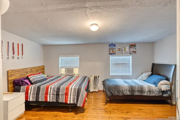 a bedroom with a bed and wooden floor