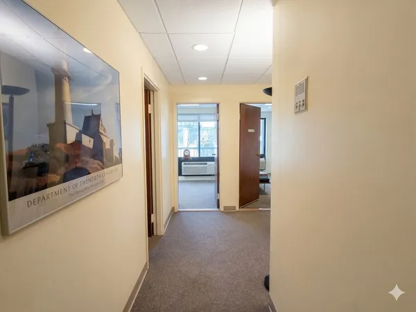 a view of a hallway with a livingroom and furniture