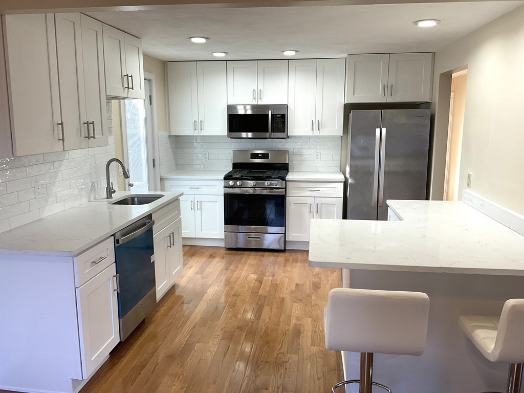 28 Standish Road Needham, MA 02492 - Photo 7 of 29 a kitchen with kitchen island granite countertop a sink stainless steel appliances and cabinets