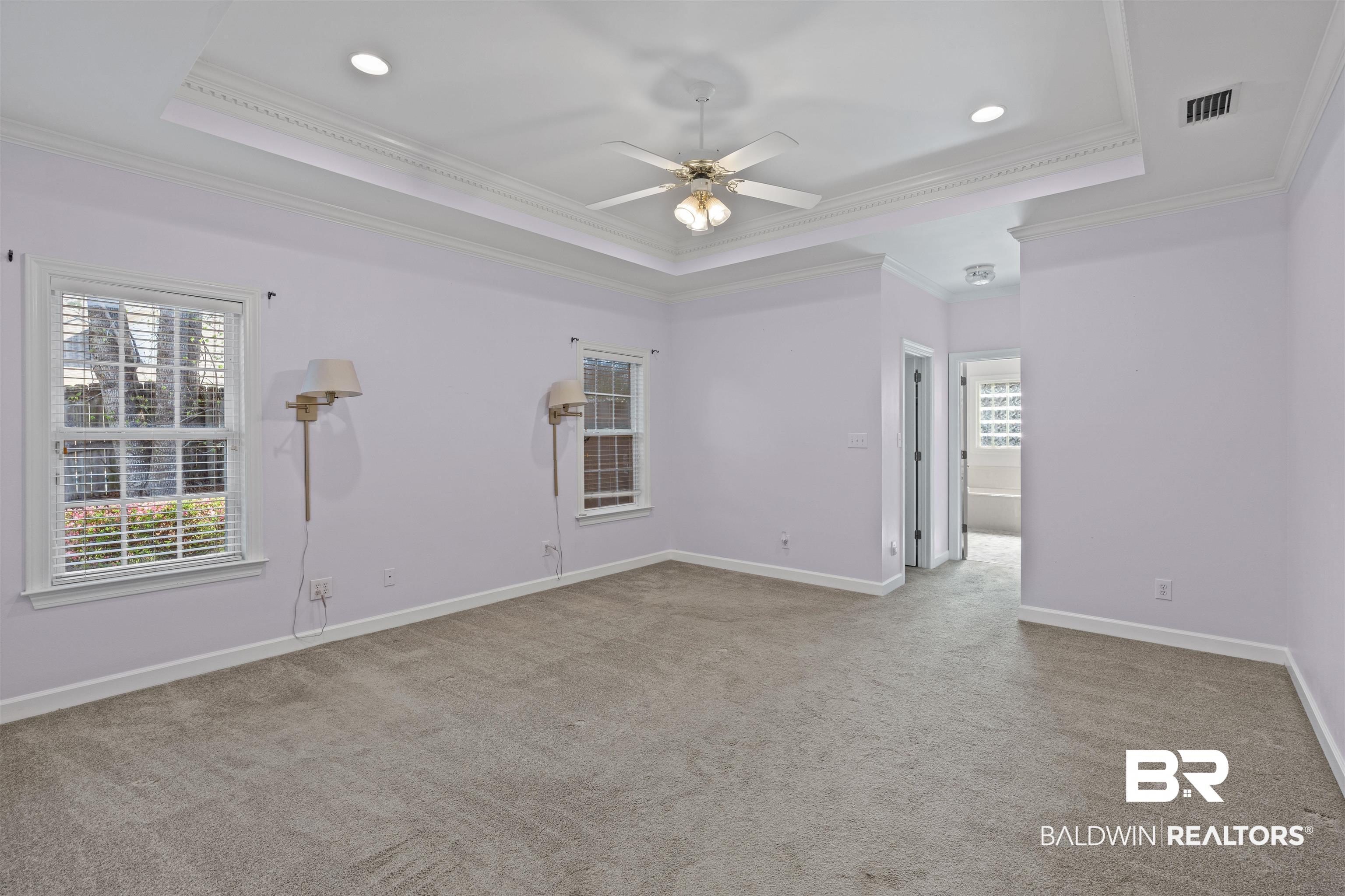 4 Judd Trail Daphne, AL 36527 - Photo 24 of 45 Carpeted empty room with visible vents, baseboards, ornamental molding, a raised ceiling, and a ceiling fan