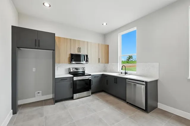 a kitchen with stainless steel appliances granite countertop a sink and a refrigerator
