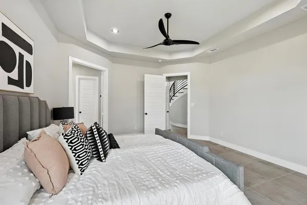 a bedroom with a large bed and a chandelier