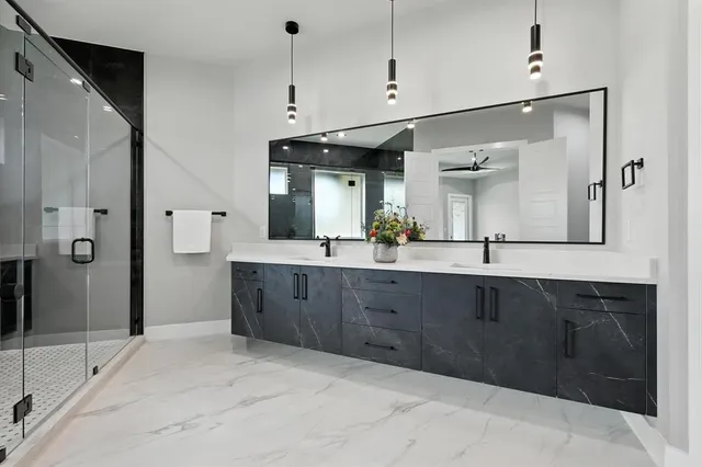 a spacious bathroom with a granite countertop sink mirror and shower