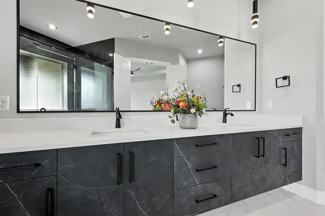 a bathroom with double vanity and a mirror