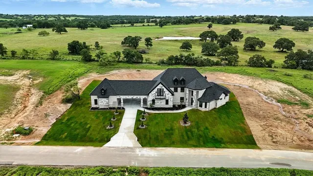an aerial view of a house with outdoor space and lake view