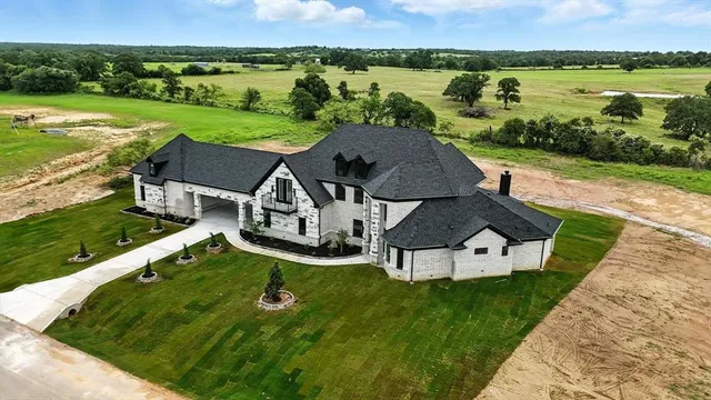 an aerial view of a house with a big yard
