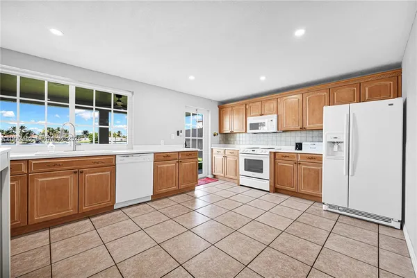 a kitchen with stainless steel appliances kitchen island granite countertop a sink and cabinets