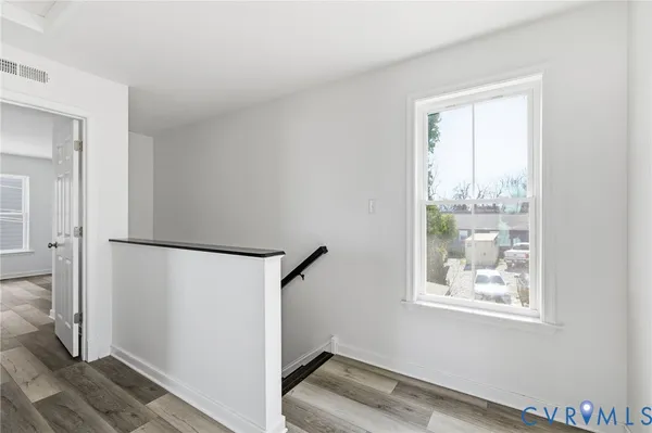 a view of a room with wooden floor and a window