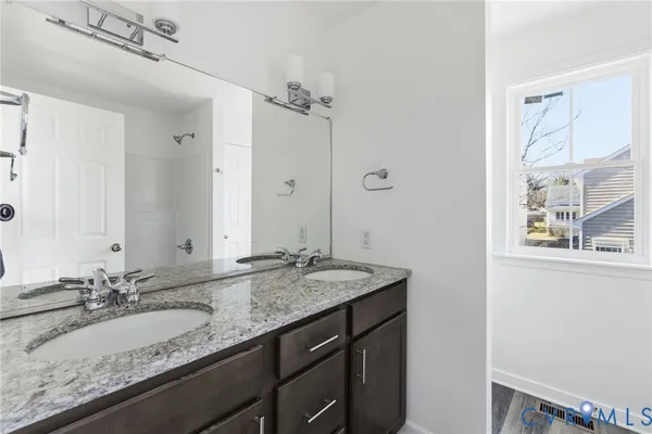 a bathroom with a granite countertop sink and a mirror