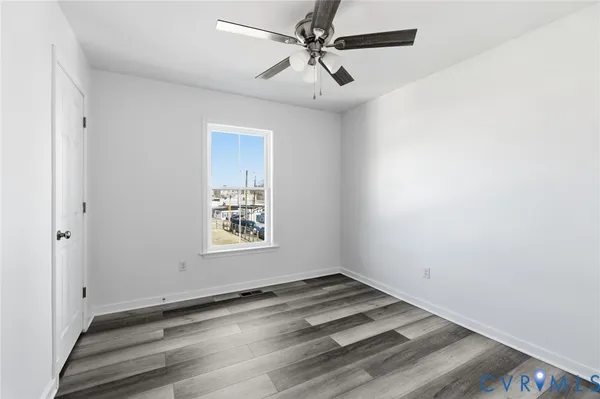 an empty room with a window and ceiling fan