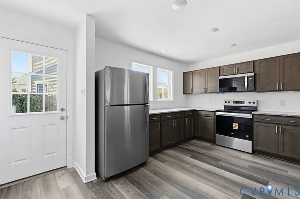a kitchen with stainless steel appliances granite countertop a refrigerator stove and a sink