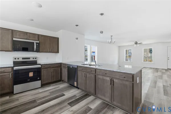 a kitchen with stainless steel appliances granite countertop a stove a sink and a microwave