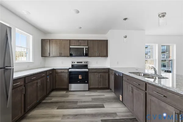 a kitchen with stainless steel appliances granite countertop a sink stove and refrigerator