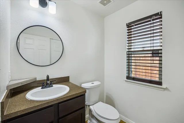 a bathroom with a sink a toilet and a mirror