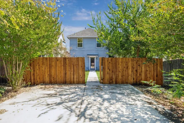 a view of backyard with potted plants and a large tree