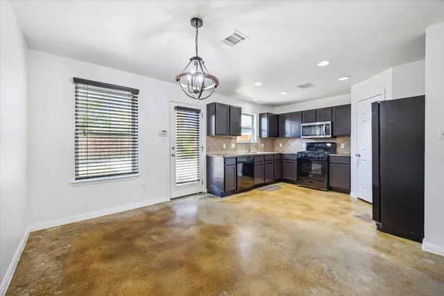 a large kitchen with stainless steel appliances granite countertop a stove and refrigerator