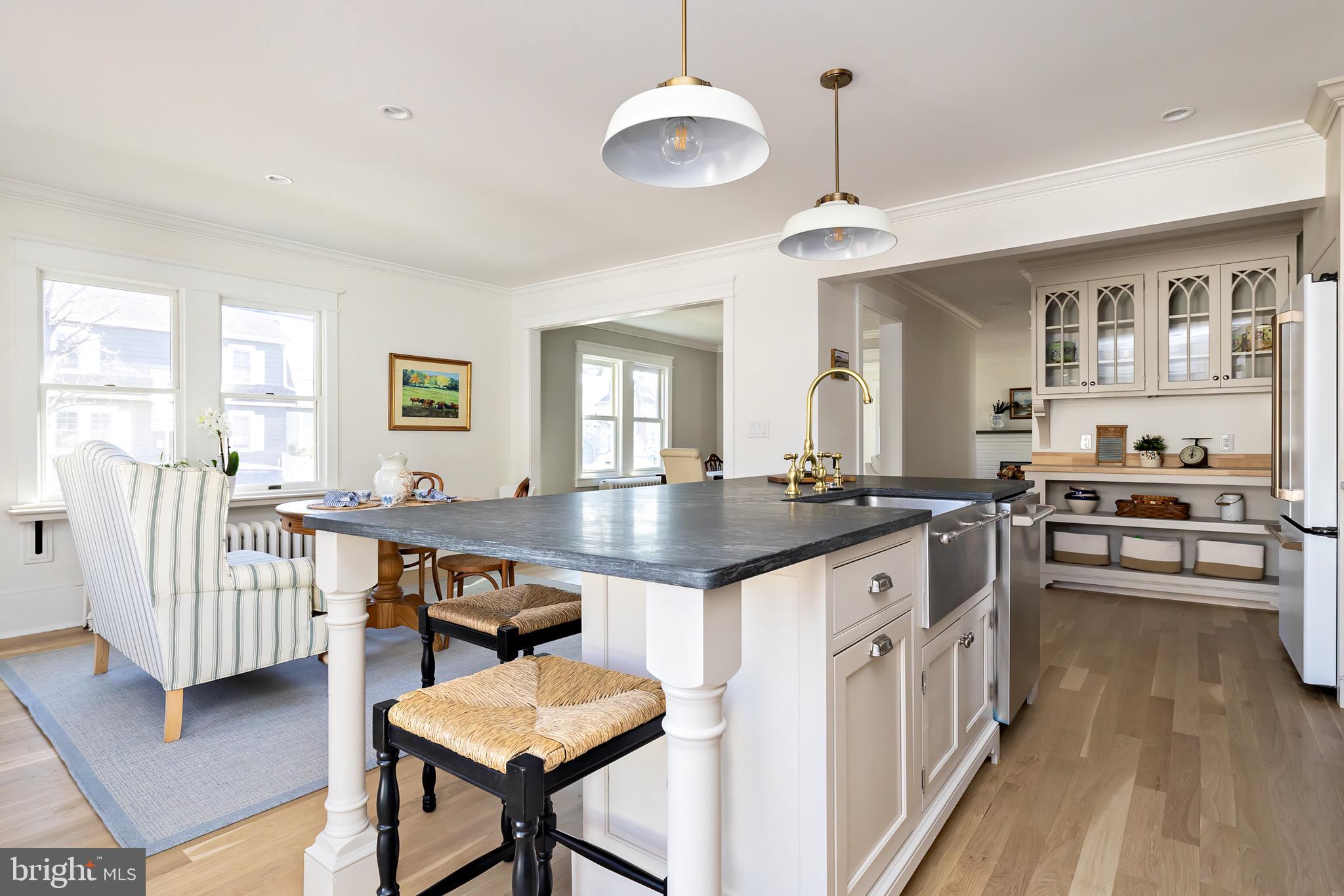 131 Marne Avenue Haddonfield, NJ 08033 - Photo 16 of 33 a kitchen with granite countertop a stove a sink a dining table and chairs with wooden floor