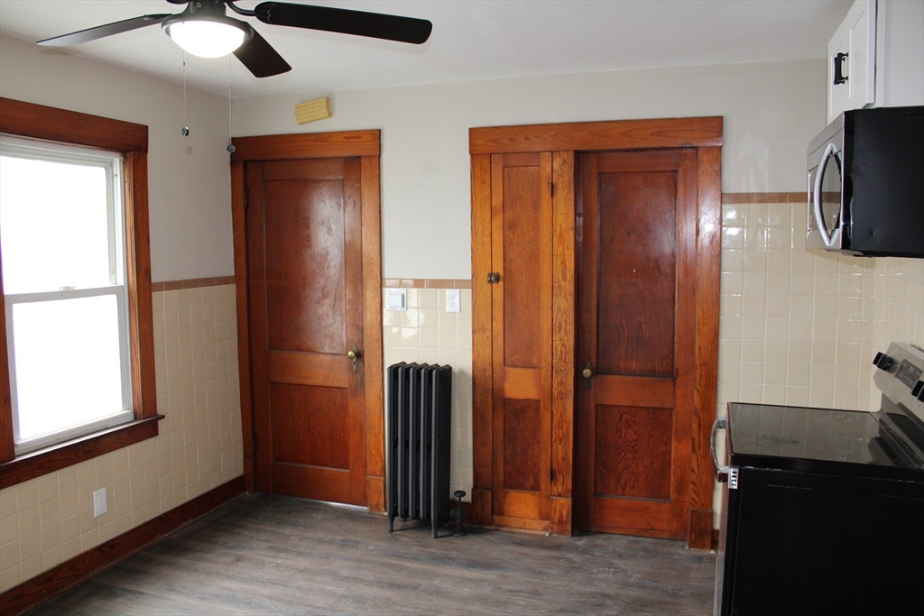 32 Kent Road Springfield, MA 01129 - Photo 5 of 30 an empty room with wooden floor cabinet and windows