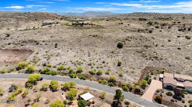 a view of a dry yard with mountains in the background