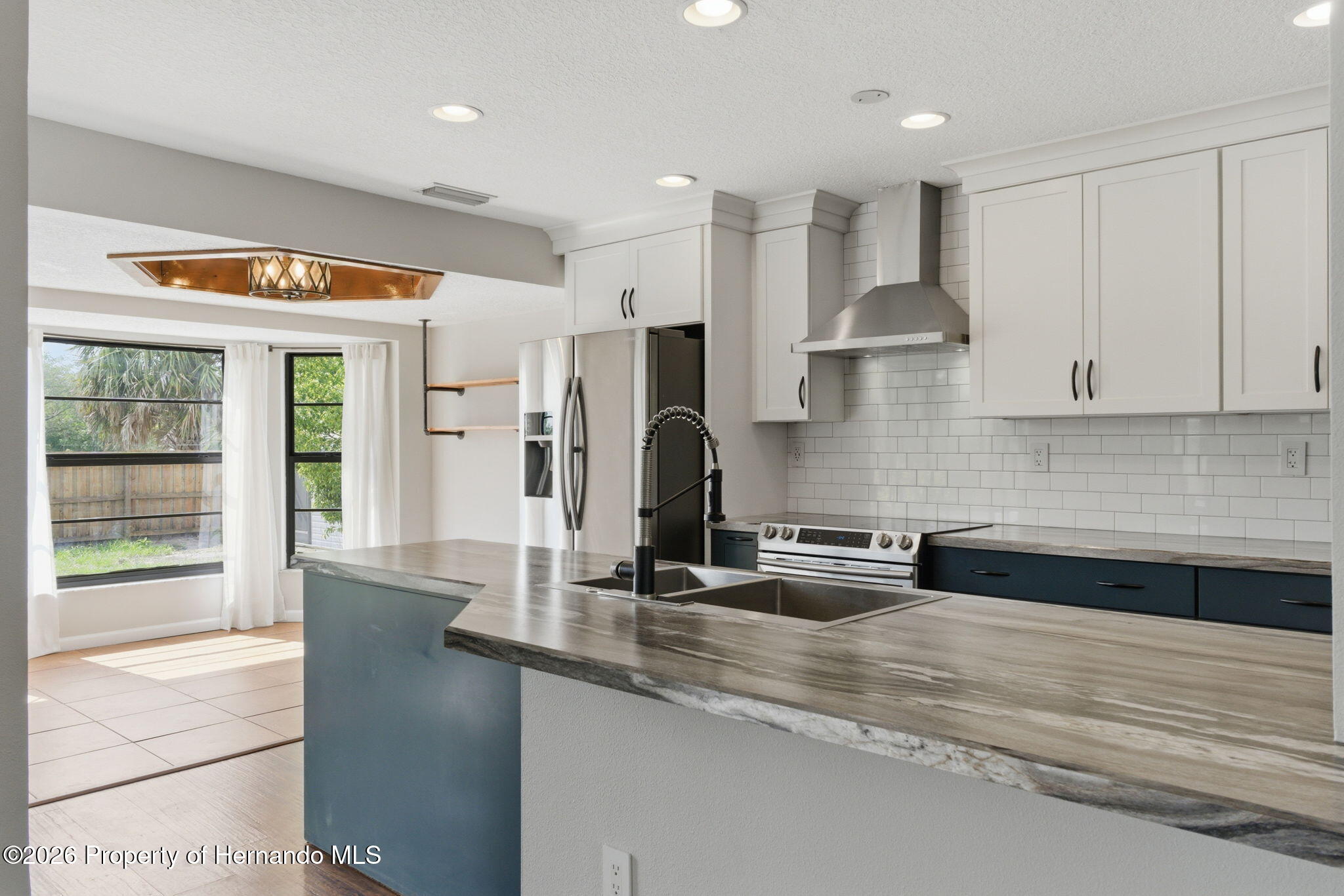 4966 Keysville Avenue Spring Hill, FL 34608 - Photo 20 of 50 a kitchen with stainless steel appliances granite countertop a sink and a refrigerator